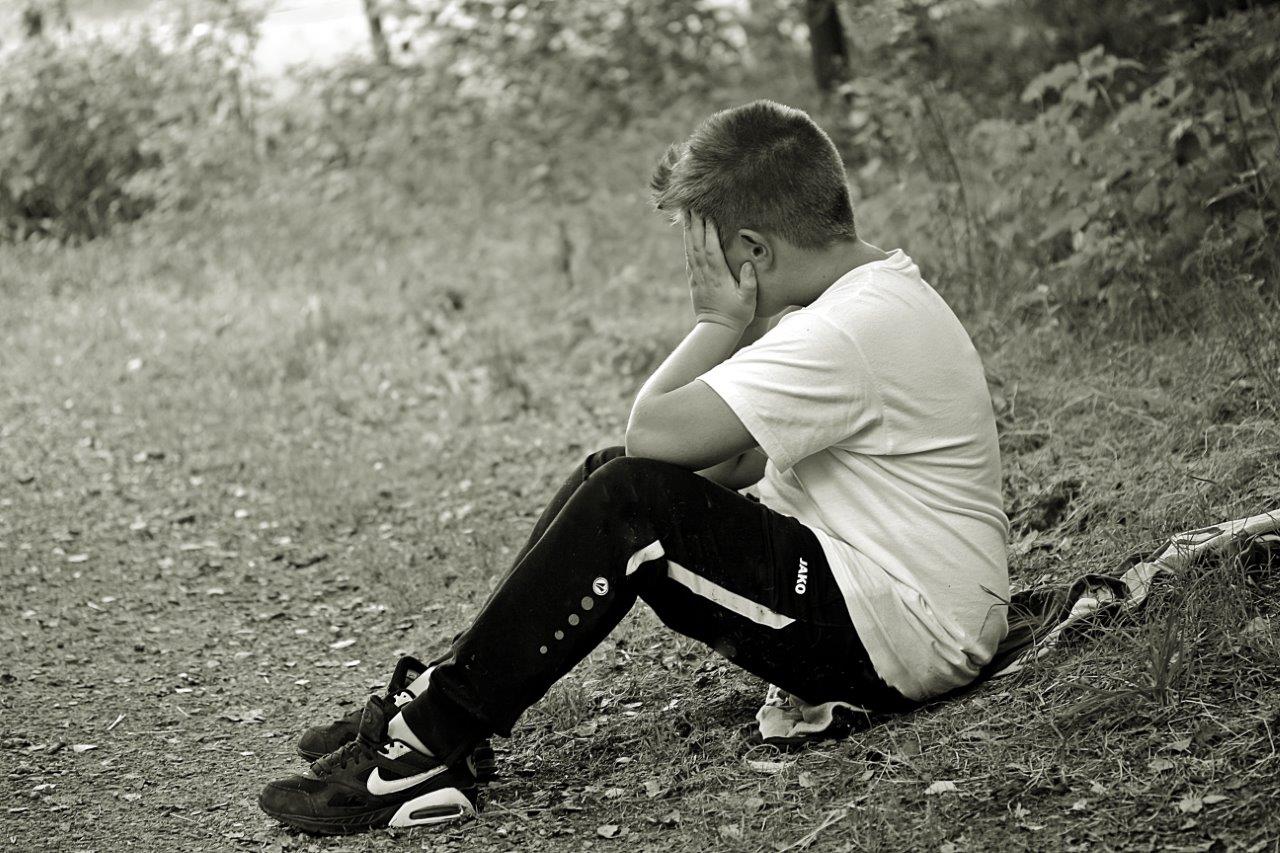 boy sat alone sad